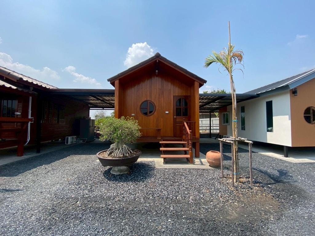 a small cabin with a palm tree in a courtyard at Gun Eng Resort กันต์เองรีสอร์ท in Ban Nong Nam Sang