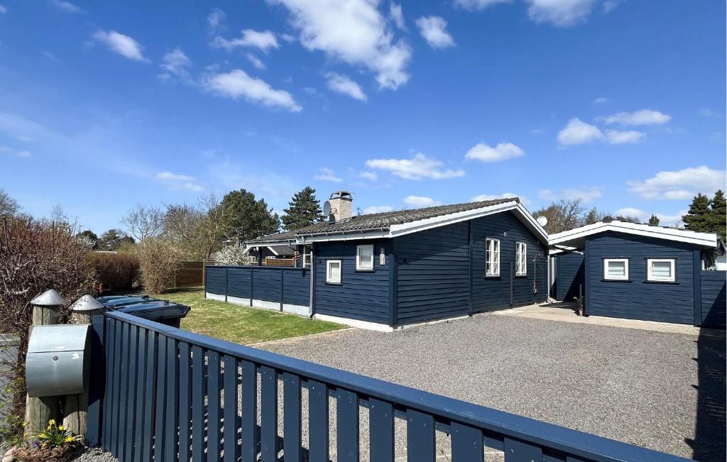 a blue house with a fence in front of it at 2 Bedroom Amazing Home In Slagelse in Slagelse