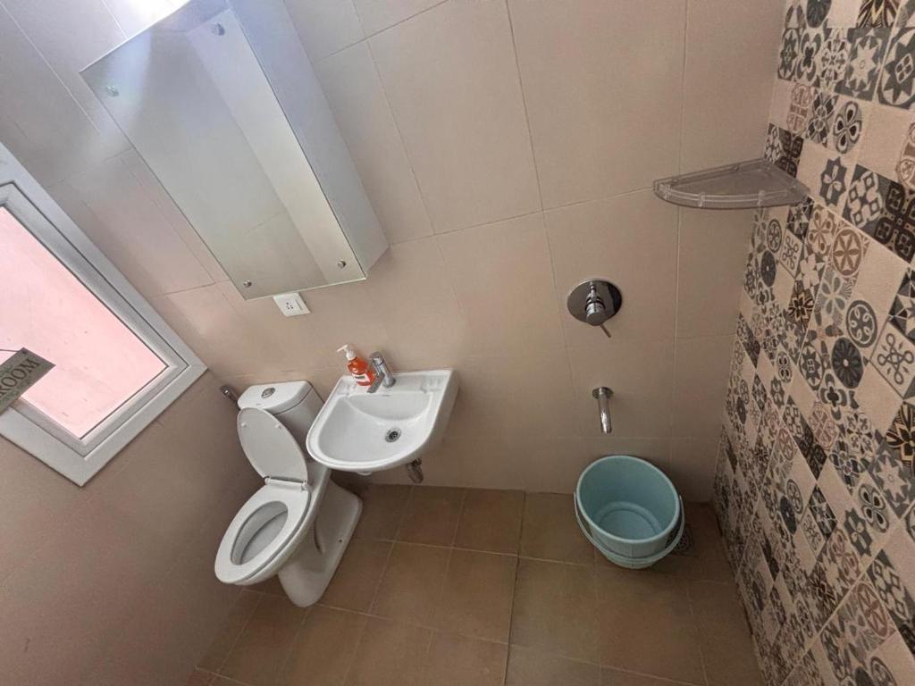 a small bathroom with a toilet and a sink at Podcast House in Chikmagalūr