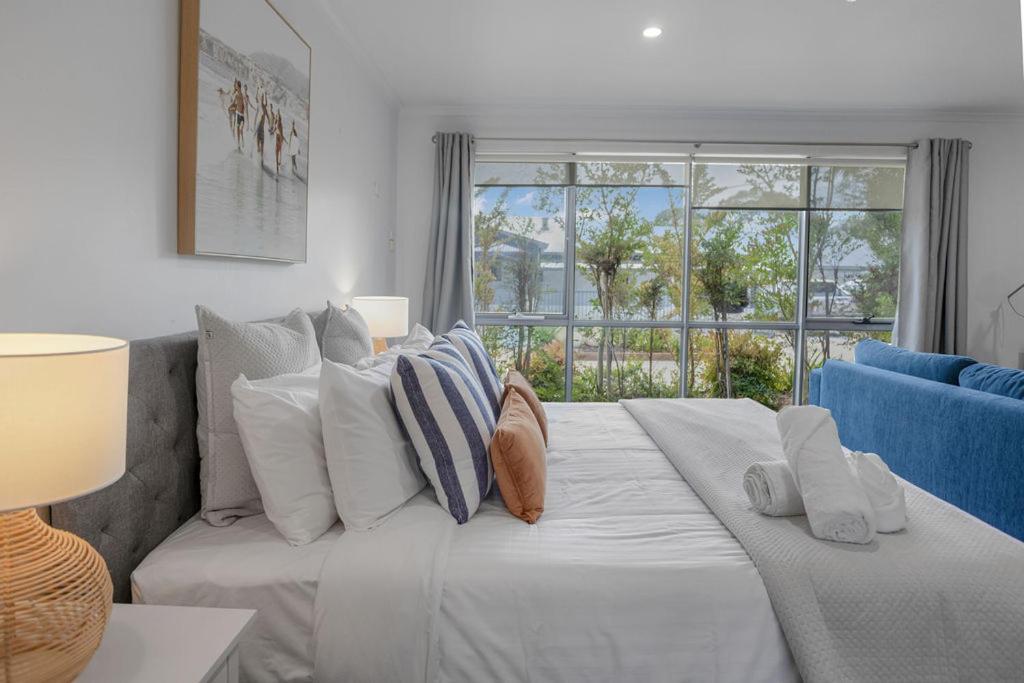 a large white couch in a living room with a window at Bay View - Lounge Lovers in Lorne