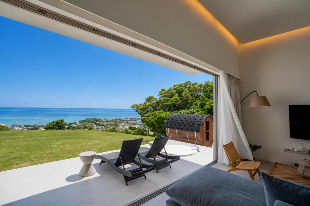 a living room with a view of the ocean at Tamagusuku Terrace in Nanjo