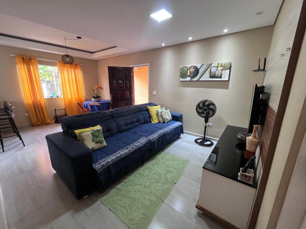 a living room with a blue couch and a television at A Casa da Sogra in Bertioga
