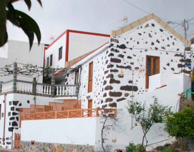 a white house with a rock wall at Casa Rural de 1945 Dos Plantas Patio Y Barbacoa in Frontera