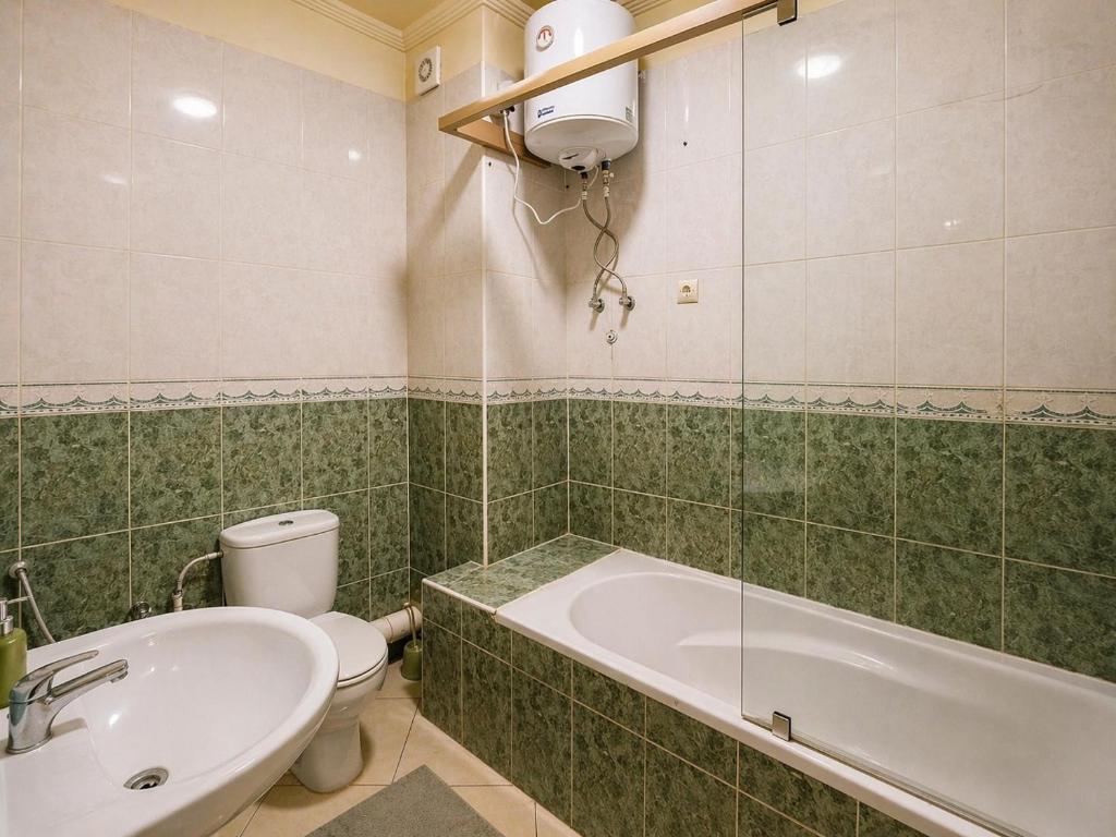 a bathroom with a tub and a toilet and a sink at Résidence El Harti in Marrakesh