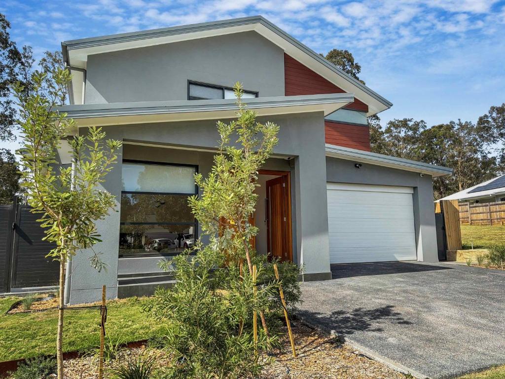 a house with a garage in front of it at Sereno in Pokolbin