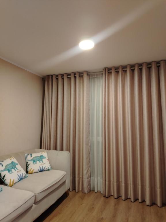 a living room with a couch and curtains at Depa en Comas in Lima