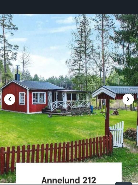 a small red house in a yard with a fence at Nature & Tranquility in Örebro