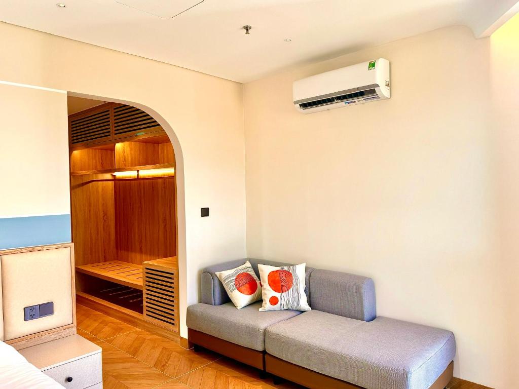 a living room with a couch and a air conditioner at The Sol Hotel in Phú Quốc