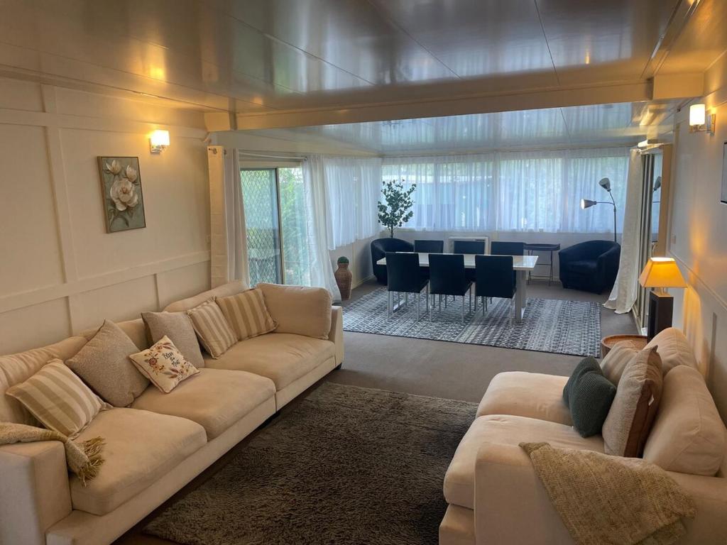 a living room with a couch and a dining room at Easy Wagga Stopover, Spacious & Comfortable in Forest Hill