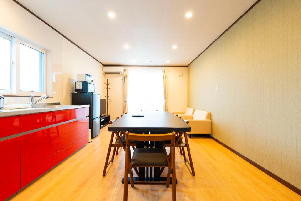 a kitchen with a table and chairs in a room at アドベンまで5分で4連棟の最大30名のゲストハウス in Shirahama