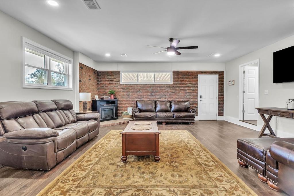 a living room with leather furniture and a brick wall at The Friendship House in Columbus