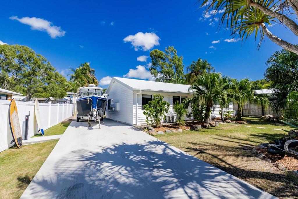 a boat is parked on the driveway of a house at Anchor and Palms in Agnes Water