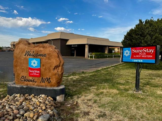 a sign in front of a building with a large rock at SureStay Plus by Best Western Cannon A.F.B. in Clovis