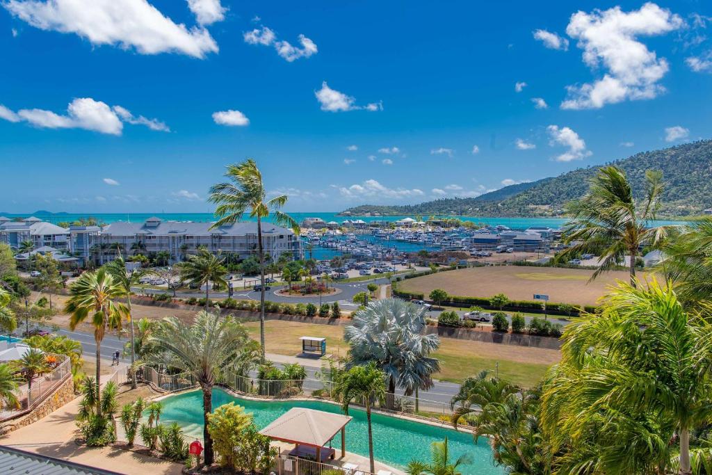 an aerial view of a resort with a pool and palm trees at Spa Haven 17B Ocean View in Airlie Beach