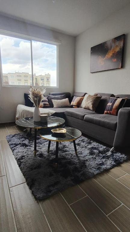 a living room with a couch and a table at Comfortable apartment with parking near AIFA in Santa Cruz Tecamac