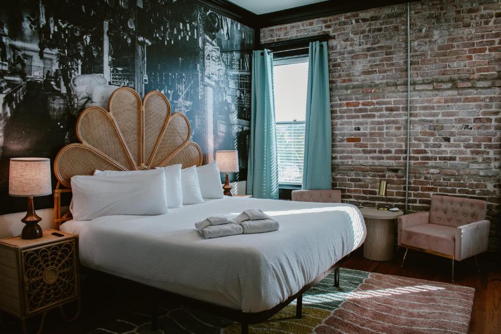 a bedroom with a large bed with towels on it at The Montgomery by Visit Apalach in Apalachicola