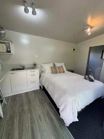 a bedroom with a white bed and a sink at 40 Winks in Otorohanga