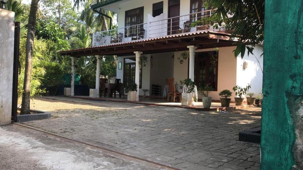 a house with a balcony and a patio at Feel side villa in Induruwa