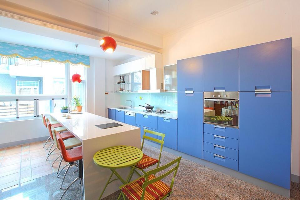 台東市的住宿－星光民宿，厨房配有蓝色橱柜和桌椅