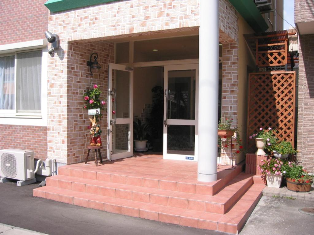 a brick house with steps leading to a door at Guest House Bamboo in Morioka