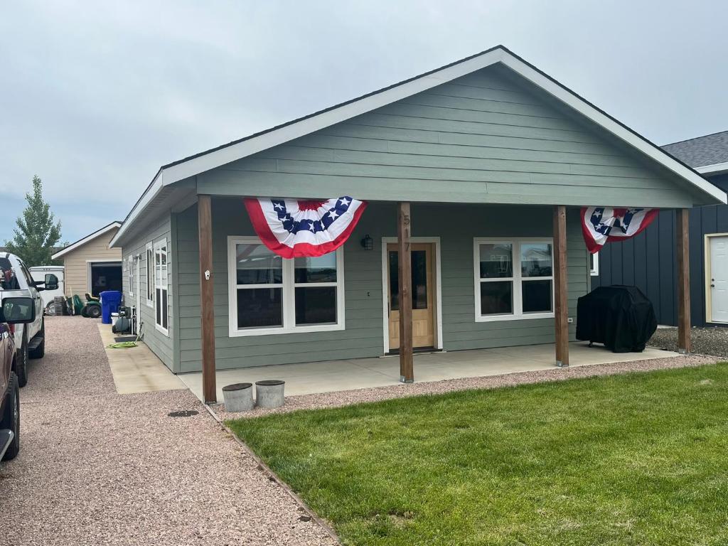 a green house with american flags on it at Charming New Lake House in Pierre