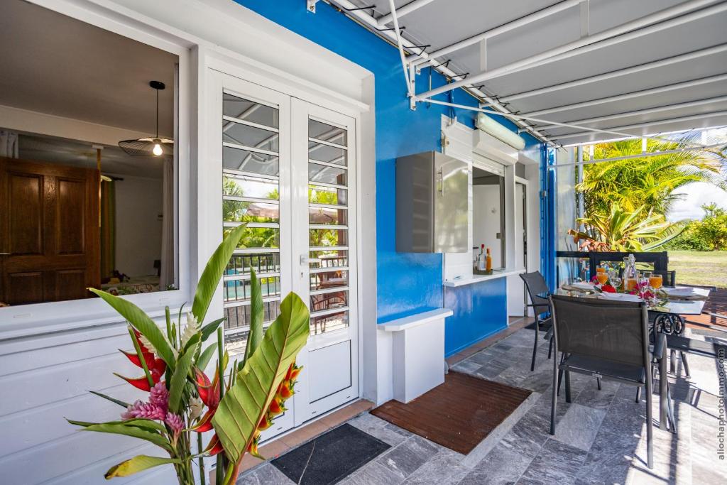 a house with a blue wall and a dining room at Proprizen in Rivière-Salée