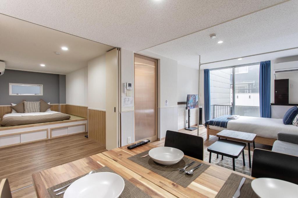 a hotel room with a bed and a dining room at 金洲House 懿-下寺 in Osaka