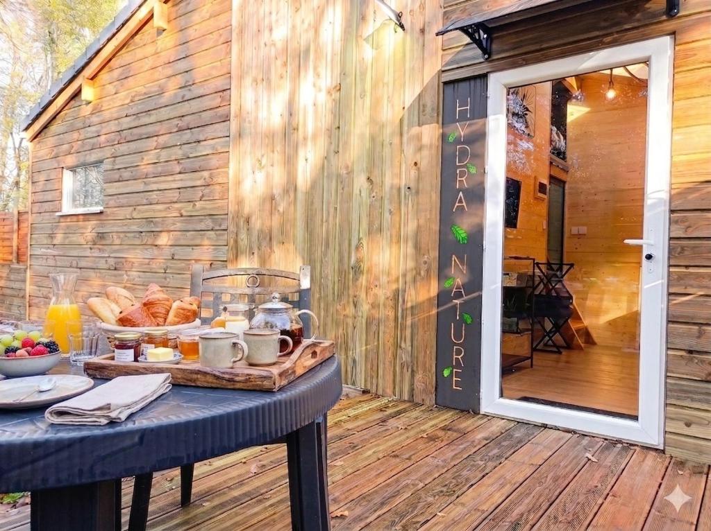 a table with a tray of food on a deck at Gîtes Hydra Charme et Nature proche Honfleur en Normandie in Conteville