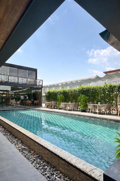 a large swimming pool with tables and chairs in a building at ไดมอนด์ โฮเทล in Ban Krasang
