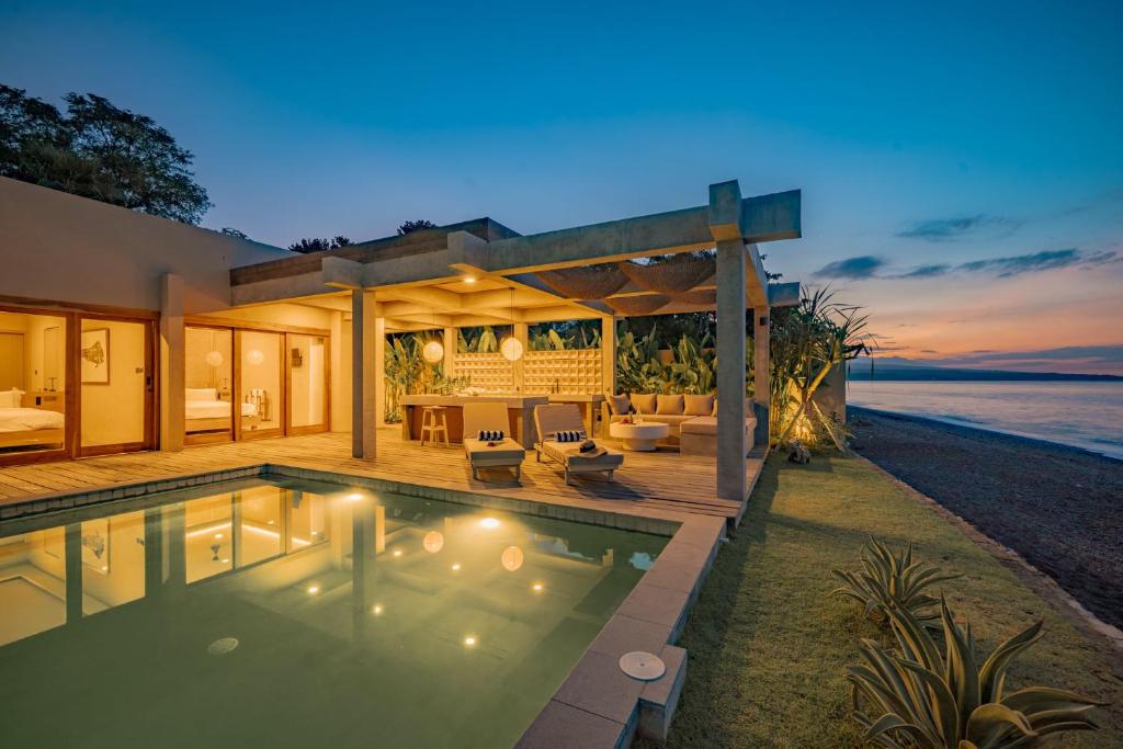 a villa with a swimming pool at night at Salty Breeze Amed in Ambat