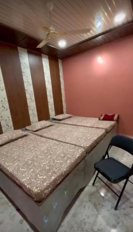 a bed and a chair in a room at Shree ram lodge in Maihar