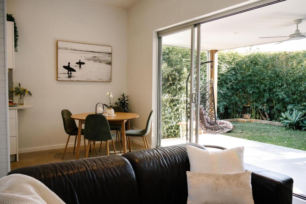 a living room with a couch and a table at The Waratah House - Modern Coastal Retreat near Cafes & Beach in Mona Vale