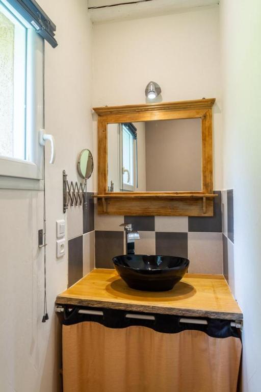 a bathroom with a black sink and a mirror at La source du cellier 4/6 personnes in Saint-Jean-la-Fouillouse