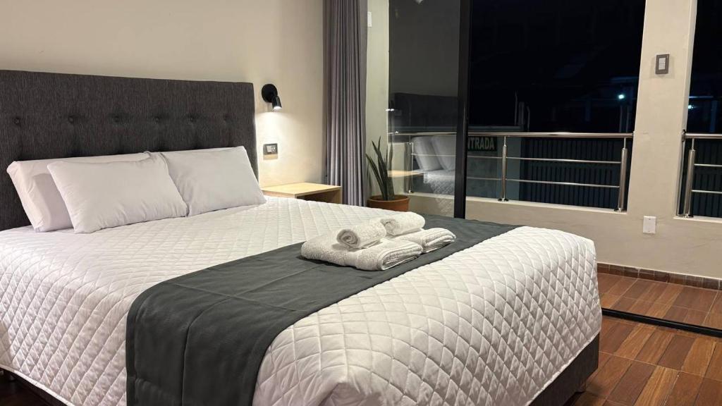 a bedroom with a bed with two towels on it at Samakuy Home Arequipa in Arequipa