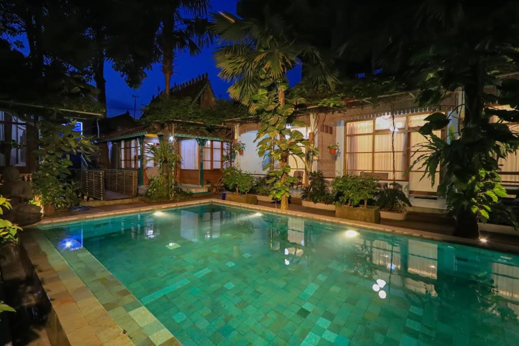a swimming pool in front of a house at night at Kalipura Villa - Private Pool & Nature Escape in Bantul
