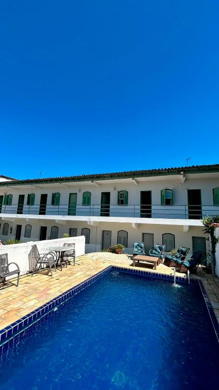 a hotel with a swimming pool in front of a building at Pousada Angellus in Paraty