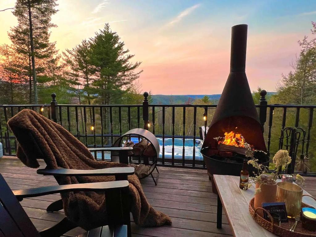 a fireplace sitting on a deck with a table with a fire at Mountain View Chalet Ski, Hot Tub, Firepit, Games in Lexington