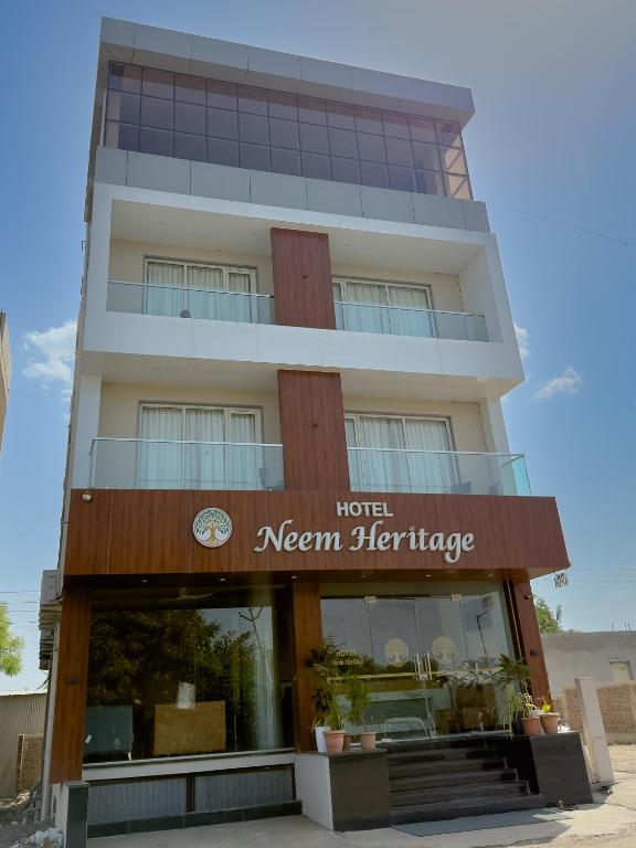 a hotel with a sign in front of a building at Hotel Neem Heritage in Shirdi