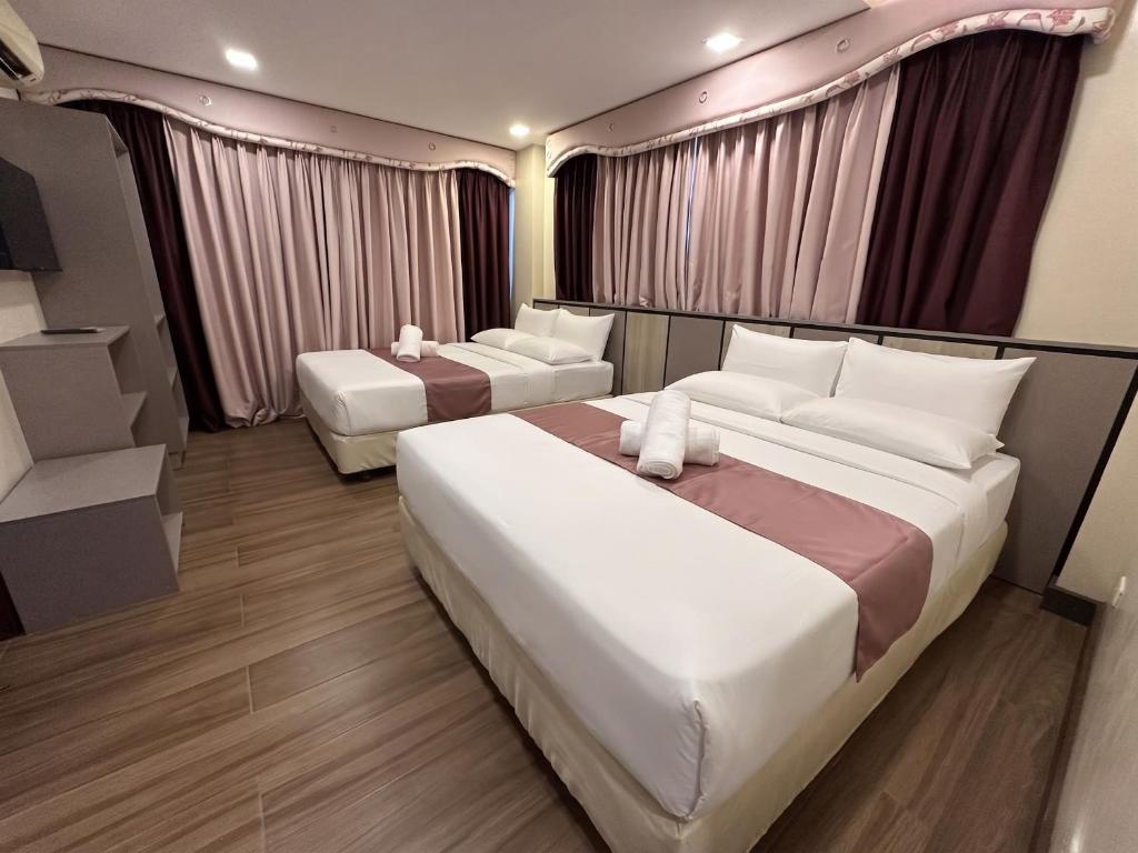 a hotel room with two beds and curtains at Cambridge Guest House in Mandaue City