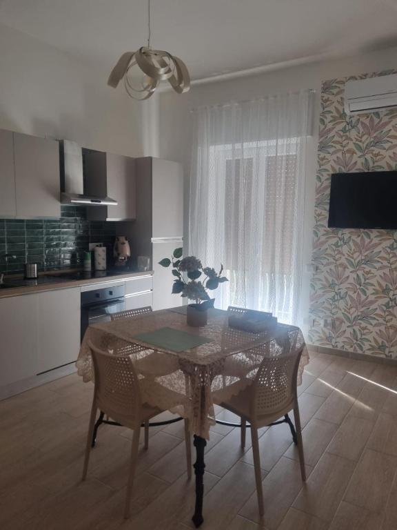 a dining room with a table and chairs and a kitchen at Dimora al Borgo in Cava deʼ Tirreni