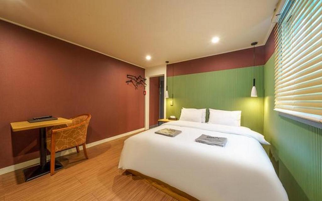 a bedroom with a large white bed and a desk at My 24 Motel in Incheon