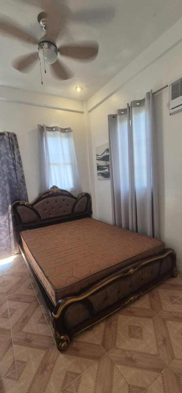 a bed in a room with a ceiling fan at White Beach Villa in Dauis
