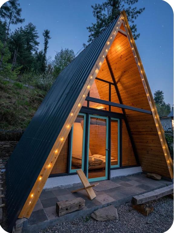 a small house with a roof with lights on it at The Crystal Cabin in Jibhi