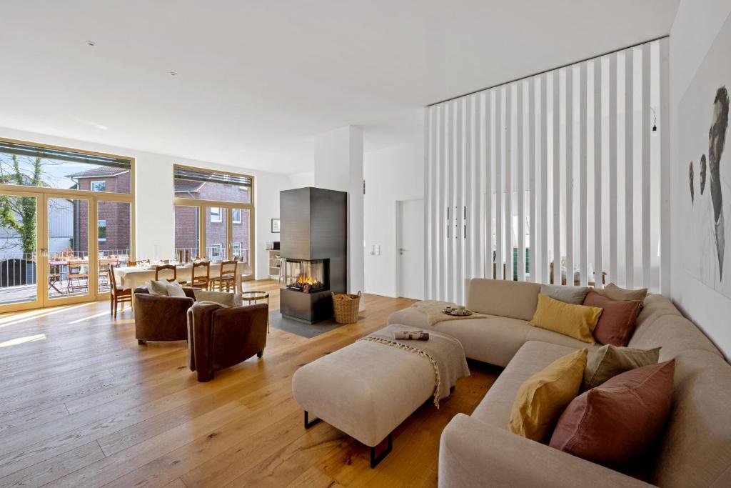 a living room with a couch and a fireplace at ACKERBÜRGERHAUS - Historische Ferienwohnung mit 4 Schlafzimmern, Kamin, Sauna, Balkon-Terasse, Altstadt und See 5 Min zu Fuß, Moderne Küche, Parkplatz, WLAN in Eutin