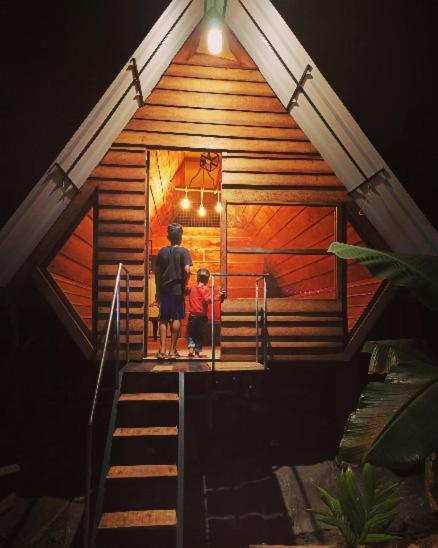 a man and a child standing in the front of a cabin at Deep Villa in Batheri