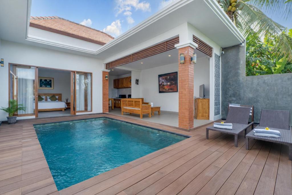 a villa with a swimming pool and a bedroom at Villa Bawa in Ubud
