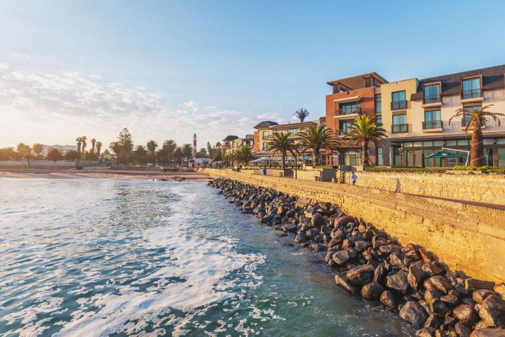 a row of rocks in the water next to a beach at Strand Hotel Swakopmund in Swakopmund