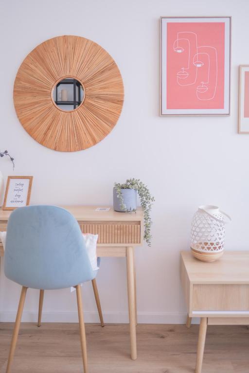 a desk with a blue chair and a mirror at Studio charmant au centre-ville in Charleroi