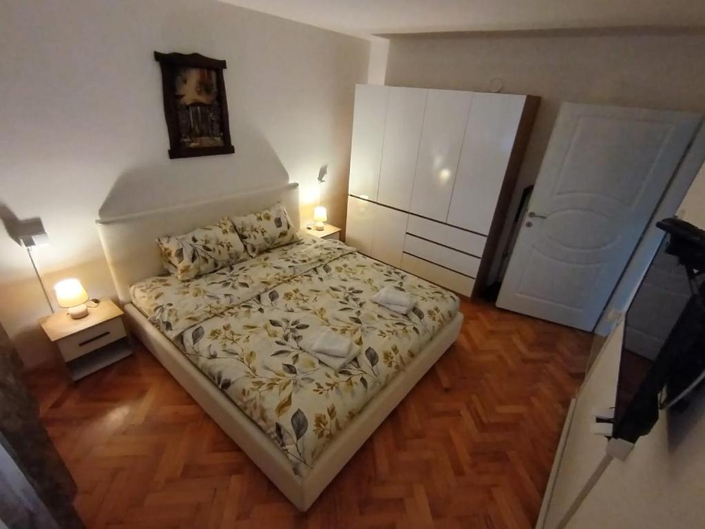 a small bedroom with a bed and a clock on the wall at Apartman Zdravković in Leskovac