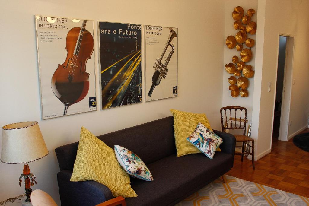 sala de estar con sofá y carteles en la pared en Apartamento Trindade en Oporto